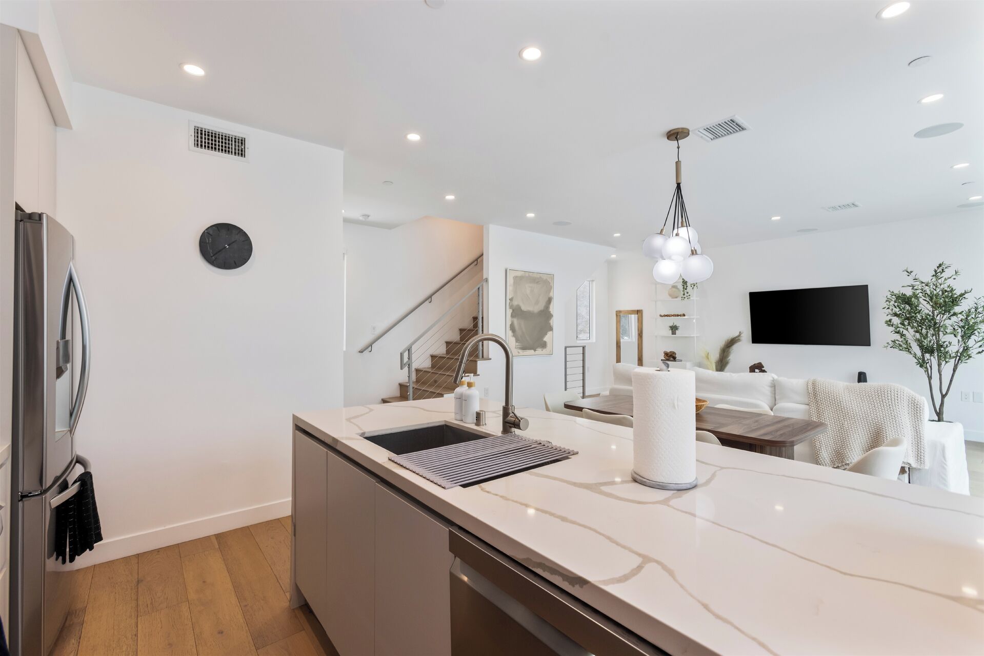 Una cocina moderna con una isla central, electrodomésticos de acero inoxidable y un diseño minimalista.