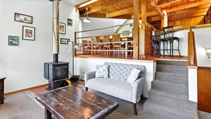 A cozy living room with a fireplace, a sofa, and a dining area with chairs. - Pet-friendly Oceanfront Getaway (Rockaway Beach)