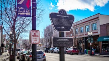 A street scene with a 'No Parking' sign, a 'Did You Know' informational sign, and a 'Phoenix, Oregon' historical marker.