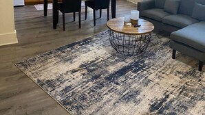 Ein geräumiger Wohnbereich mit Esstisch, Stühlen, einer Couch und einem Couchtisch.