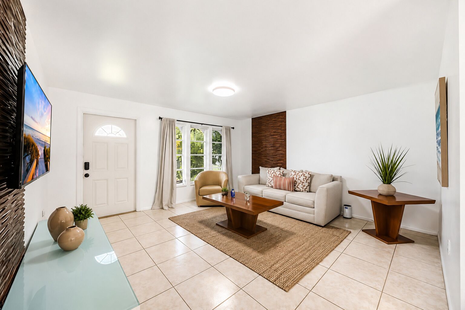 A modern living room with a sofa, coffee table, and a TV mounted on the wall.