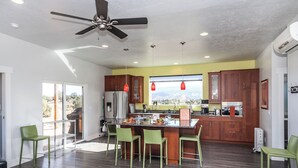 Una cocina moderna con una isla central, armarios de madera y vistas al exterior.