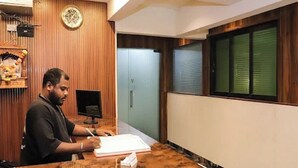 Una recepción con detalles de madera, un reloj en la pared y una ventana con persianas.