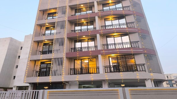 A multi-story building with balconies and string lights. - Hotel Ratna Residency (Panvel)