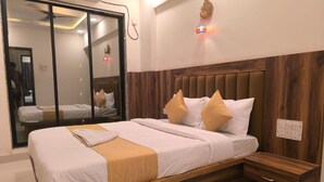 Una habitación de hotel con un cabecero de madera, ropa de cama blanca y una mesita de noche de madera.