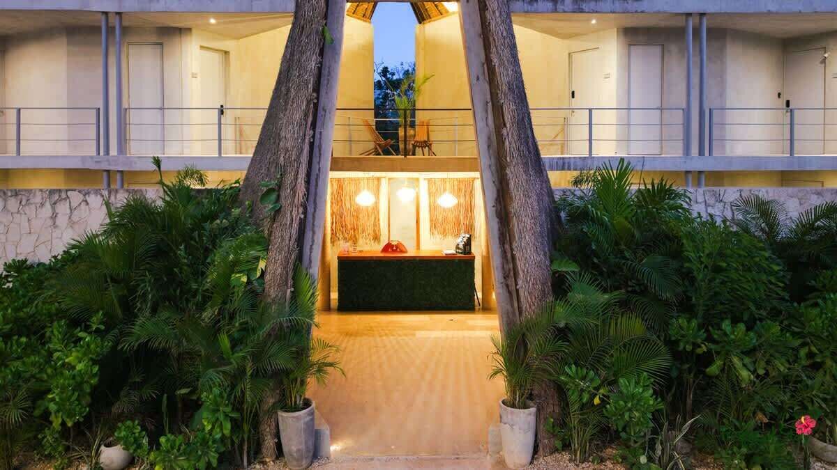 Een hotel lobby met een receptiebalie, een trap en een balkon.