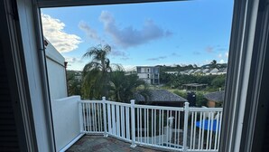 A view from a balcony with stone flooring, white railing, and a clear sky. - Breathtaking villa with private pool and hot tub, 2 minute walk from the beach. (Gros Islet)