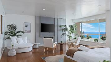 Una habitación de hotel moderna con una cama grande, un área de descanso con sillas y una mesa redonda, un televisor montado en la pared y un balcón con vistas al océano.