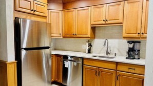 A kitchen with wooden cabinets, stainless steel appliances, a sink, and a coffee maker. - Spacious retreat with Stunning views of Mount Washington!! 3Bedroom + 2Bath (Bartlett)