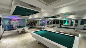 A pool hall with multiple tables, chairs, and a mural with a lion's face. - Golf & Casino Beach Villa @Dorado del Mar (Dorado)