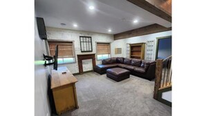 A spacious room with a large leather sofa, a wooden desk, and a bookshelf. - Restyle Farm house (Baldwin)