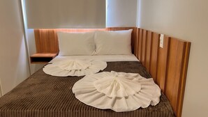 A single bed with a wooden headboard, two pillows, and two white decorative pillows on the bed. - Apto Pet Friendly com Piscina a 100m da Orla (Japaratinga)