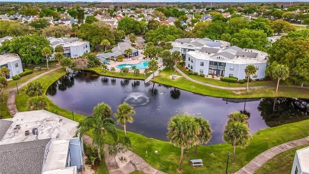 A residential area with a swimming pool surrounded by houses and greenery. - Upstay 2BR Family Condo Ventura Golf Country Club (Orlando)