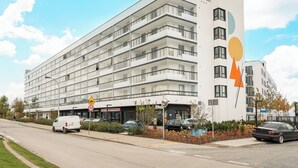 Ein mehrstöckiges Hotel mit modernem Design, mit Balkonen und großen Fenstern.