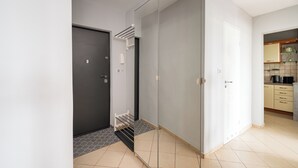 A modern kitchen with a black countertop, a white door, and a tiled floor.