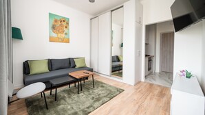 A modern living room with a sofa, coffee table, and a painting on the wall. - Marszałkowska City Centre Apartment (Warszawa)