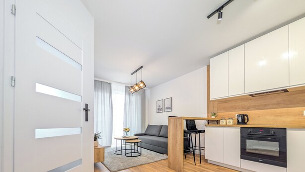 A modern apartment with a kitchen, dining area, and living room. - Artemskiej Comfort Apartment (Wrocław)