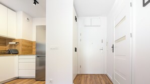 A modern kitchen with white cabinets, a wooden countertop, and a stainless steel refrigerator. - Artemskiej Comfort Apartment (Wrocław)