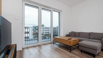 Ein modernes Wohnzimmer mit einer Couch, einem Couchtisch und einem Fernseher.