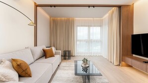 A modern living room with a sofa, coffee table, and TV. - Cracow Novum Apartment #365 (Kraków)