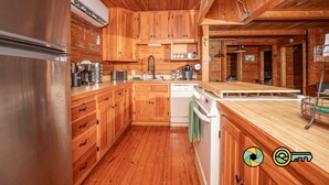 A wooden cabin kitchen with a stainless steel refrigerator, wooden cabinets, a dishwasher, and a wooden countertop. - Basye Retreat - Authentic log cabin coziness! (Mount Jackson)
