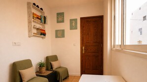 A room with two green armchairs, a white table, a wooden door, and a window. - CASA DACE Authentic West-Coast Stay (El Albercon)