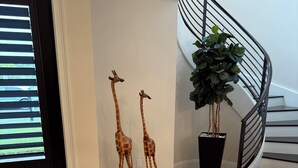 Eine Treppe mit schwarzem Geländer und einem Blumentopf daneben.