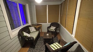 A cozy room with a ceiling fan, a sofa, two chairs, a small table, and a window with blinds. - 3-bedroom Beach House in Beautiful Charlotte near Beach with AC/Heat and Wi-Fi (Rochester)