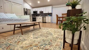Un espacio habitable compacto con kitchenette, comedor y dormitorio.