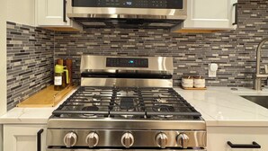 Una cocina con estufa, horno y microondas de acero inoxidable.