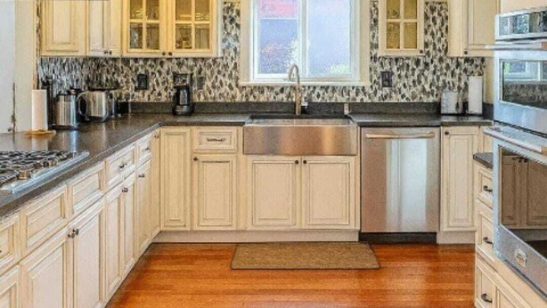 A kitchen with white cabinets, a stainless steel sink, and a window above the sink. - 
Spacious 5-Bedroom Retreat Minutes from Washington (Virginia)