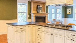 A kitchen with white cabinetry, a central island, and a built-in stove. - 
Spacious 5-Bedroom Retreat Minutes from Washington (Virginia)