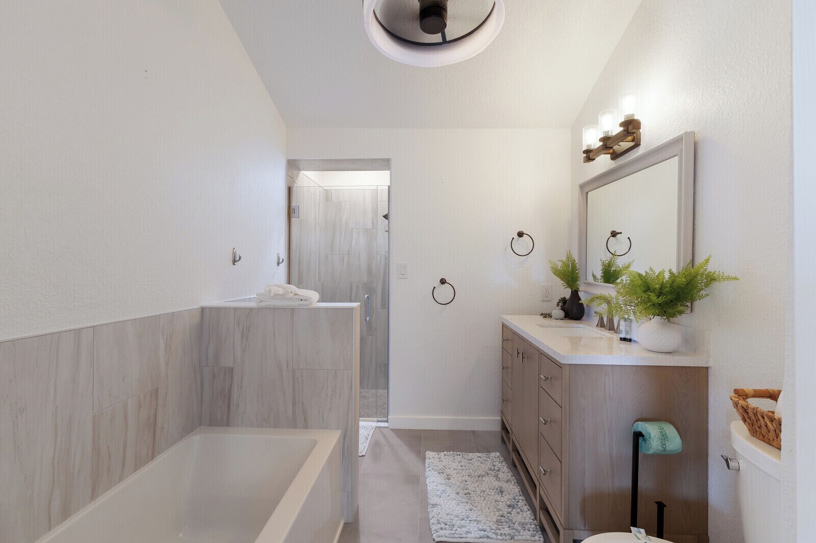 Un baño moderno con bañera, ducha y tocador con espejo.