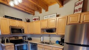 A kitchen with wooden cabinets, stainless steel appliances, and a stainless steel refrigerator.