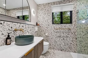 A bathroom with a terrazzo floor, a round sink, a toilet, and a window with a view of greenery. - The Noosa Villa Luxe Townhouse in Great Location (Noosa)