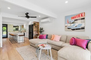 Ein modernes Wohnzimmer mit einer Couch, einem Couchtisch und einer Küchenzeile mit einer Bar.