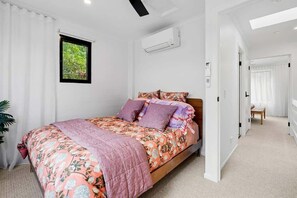 A bedroom with a bed, a window, an air conditioning unit, and a hallway. - The Noosa Villa Luxe Townhouse in Great Location (Noosa)