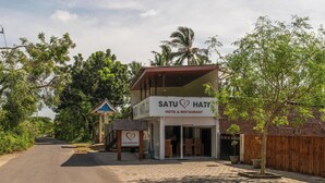 Un edificio de dos pisos con un letrero que dice 'Satu Hotel & Restaurant'.