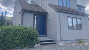 Un edificio moderno de dos pisos con una puerta azul y ventanas grandes.