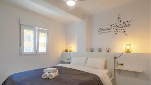 Une chambre d’hôtel avec un lit, deux lampes de chevet, un élément de décoration murale et une fenêtre.