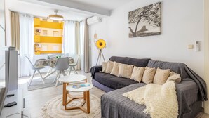Un salon moderne comprenant un canapé, une table basse et un coin repas avec des chaises et une table.