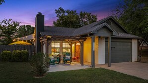 Un garage attenant à une maison, doté d’un patio couvert, d’une cheminée et d’une porte de garage.