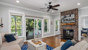 Un salón amplio con chimenea, ventanas grandes y un balcón.