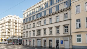 A multi-story building with a classical architectural style, featuring a ground floor with commercial spaces and upper floors with residential units. - Blueground | Alsergrund, rooftop, nr Votivkirche (Vienna)
