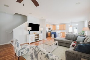 A modern living room with a sofa, a coffee table, and a TV mounted on the wall.