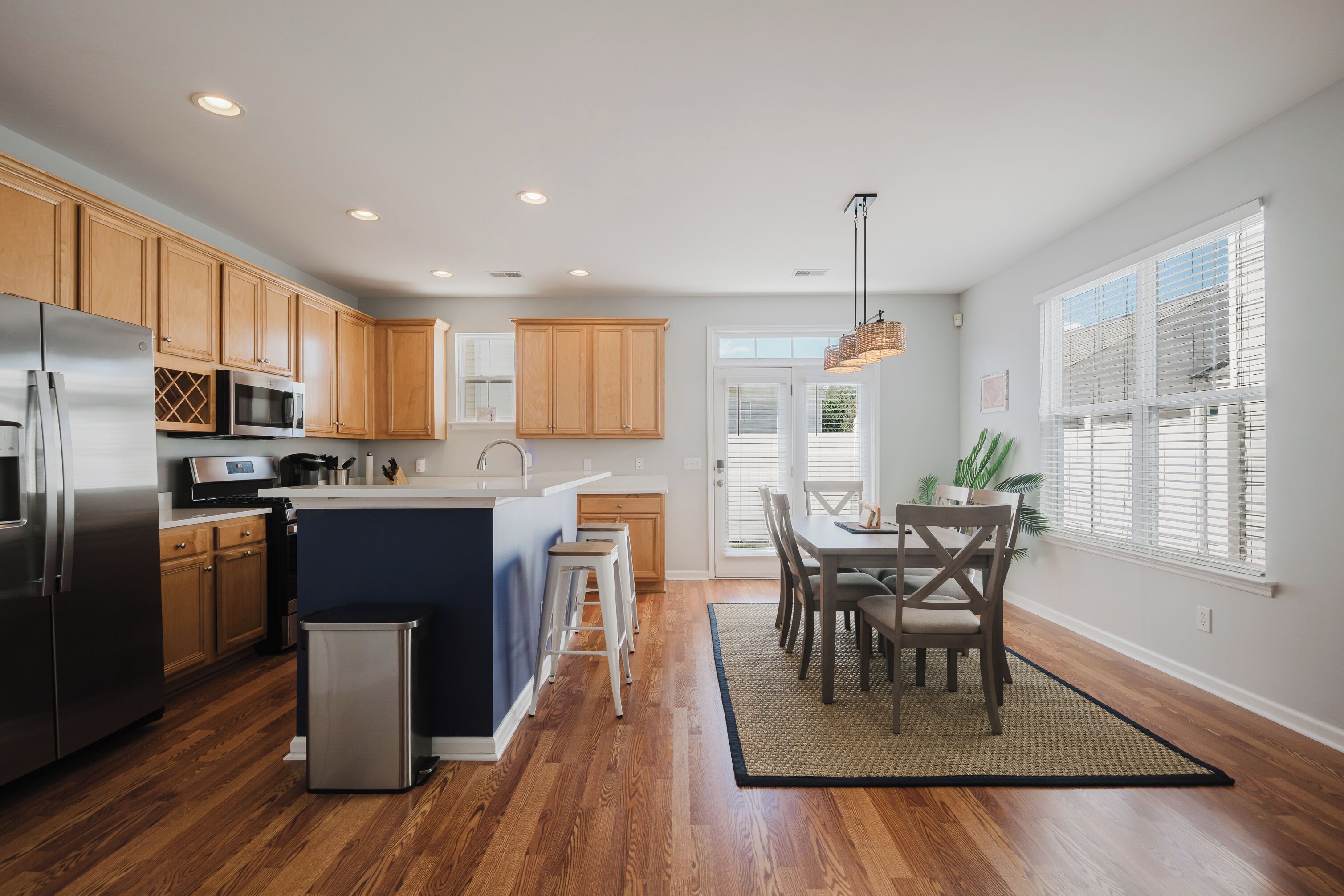 Une cuisine moderne avec des meubles en bois, des appareils en acier inoxydable et un îlot central.