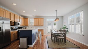 Une cuisine moderne avec des meubles en bois, des appareils en acier inoxydable et un îlot central.