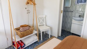 A room with a wooden clothes rack, a white chair, a small white cabinet, and a sink. - Rustic, cosy one bedroom guesthouse. Just a short walk to Umina Beach! (Umina Beach)