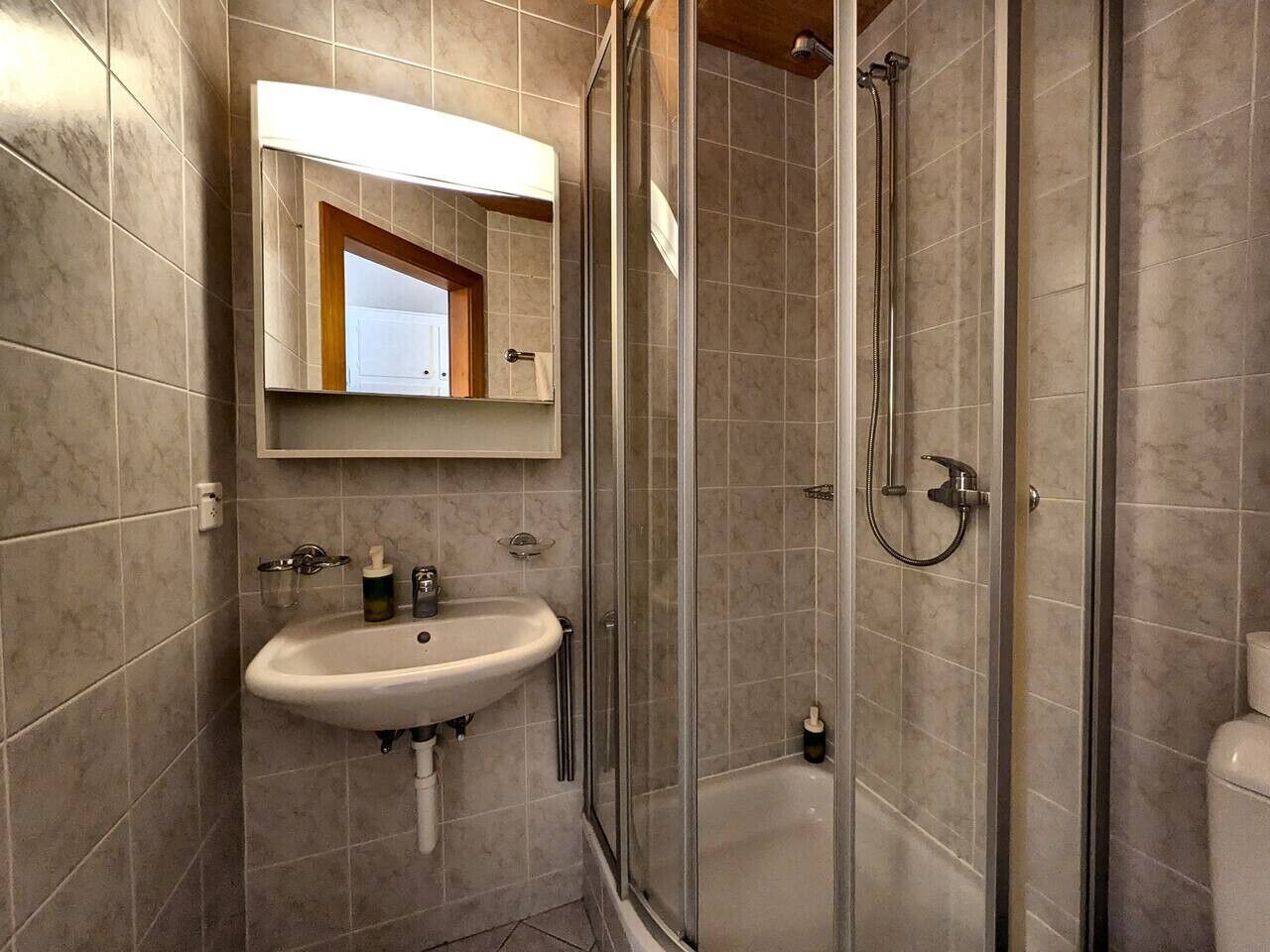 Un baño con lavabo, espejo y ducha.