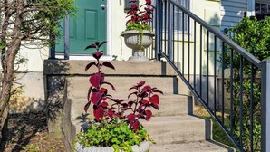 A set of concrete stairs with a metal railing, leading to a green door. - Only 8 min to Ohio State University! (Columbus)